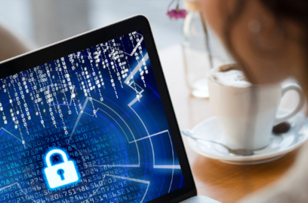 A woman is looking at her computer screen. The screen shows the icon of a lock, symbolizing a hacked website.