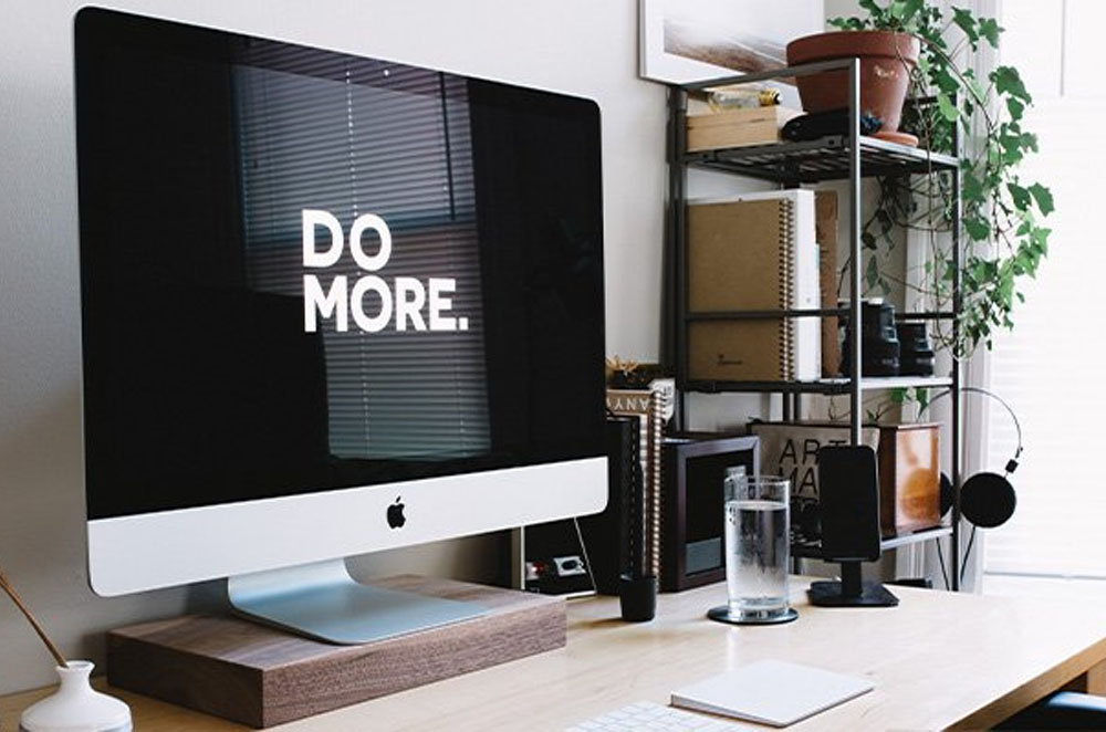 Computer on desk with 'DO MORE' on the screen